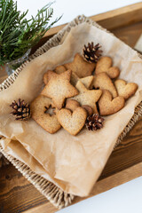 Preparation of gingerbread, different gingerbreads of different shapes lie on a wooden tray, top view. Holiday concept.