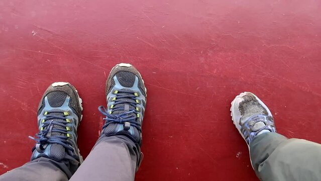 Static shot of a couple of dirty walking shoes on a red floor at Lake Natron