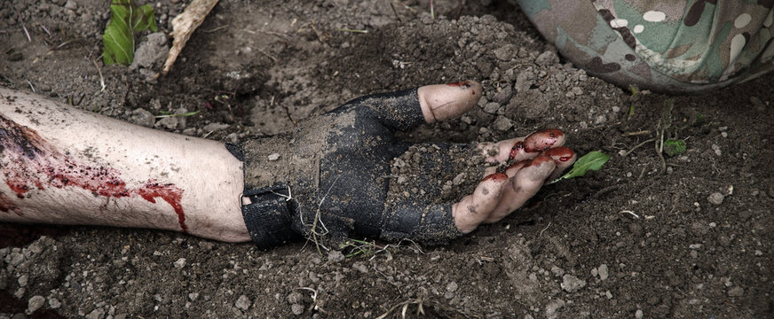 Hand of a wounded soldier covered in blood