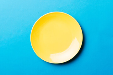 Top view of isolated of colored background empty round yellow plate for food. Empty dish with space...