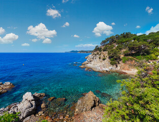 Fototapeta na wymiar Summer sea rocky coast view with trees and beach (Catalonia, Costa Brava, Spain).