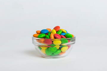 Multicolored candies in a bowl on a colored background. birthday and holiday concept. Top view with copy space