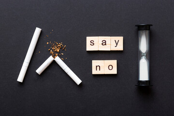 Cigarette And Wooden Blocks, Broken cigarette on table background with hourglass, No Tobacco Day...
