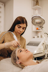 Woman undergoing procedure of vacuum hydro peeling in beauty salon