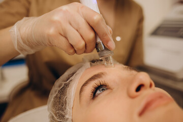 Woman undergoing procedure of vacuum hydro peeling in beauty salon