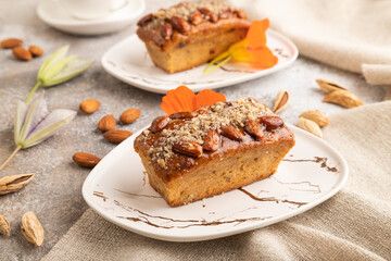 Caramel and almond cake on brown concrete, side view