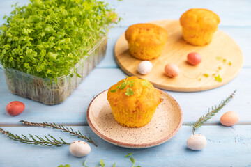 Homemade cakes with chocolate eggs and spinach microgreen on a blue, side view, selective focus.