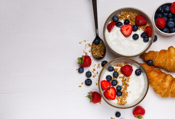 Yogurt with fruits and croissants on a white background. Breakfast.
