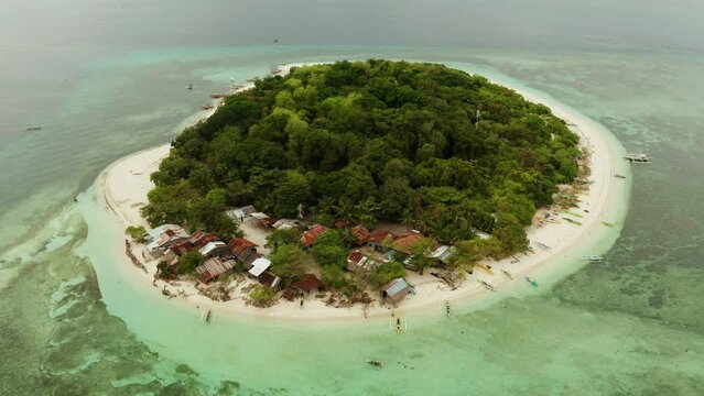 Tropical island Mantigue and sandy beach surrounded by atoll coral reef and blue sea, aerial view. Small island with sandy beach. Summer and travel vacation concept, Camiguin Philippines Mindanao