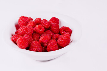 Close up of red raspberries on white background