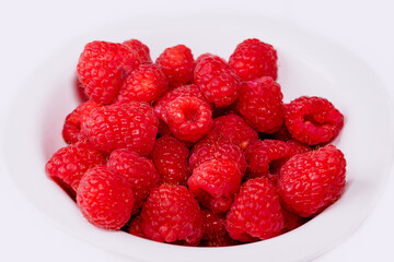 Close up of red raspberries on white background