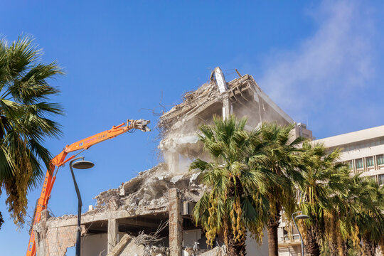 Izmir, Turley - October 02, 2022. Demolishing a old outdated building with heavy machinery. An excavator machine at a demolition construction site