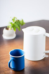 	青色のマグカップとケトルと植物｜縦位置