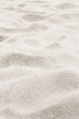 Fototapeta na wymiar Beige Sand texture natural background. Close up sandy beach sand on shore sea, waves textured dunes, minimal nature vertical fon. Summer and travel, spa and rest concept. Selective focus