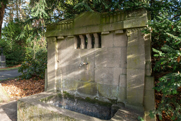schöne alte Wasserzapfstelle in schöner Steinmetzarbeit auf einem Friedhof in Osnabrück