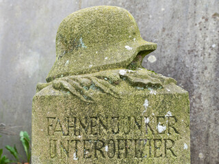 Grabstein eines gefallenen Soldaten vom zweiten Weltkrieg, Helm mit Lorbeer auf einem Friedhof in...