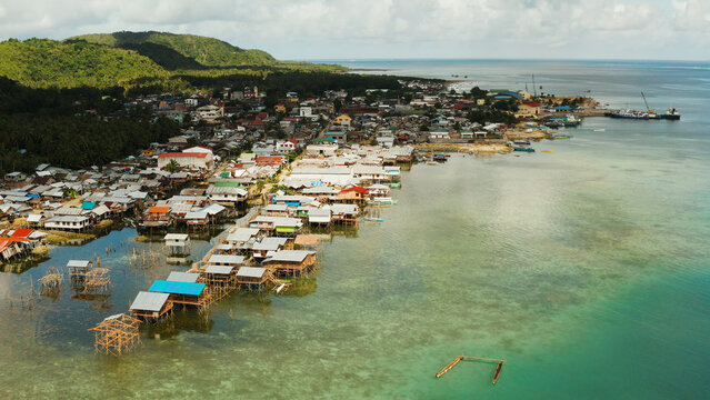 Village of stilt houses built over the sea, top view. Dapa, Siargao, Philippines.