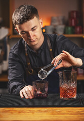 Barman putting ice ball