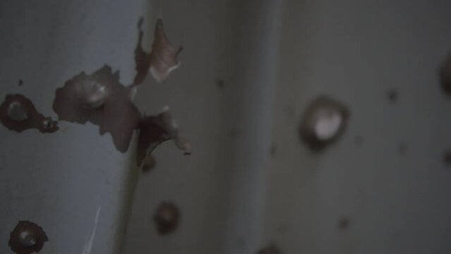 Close up of bullet holes in metal fense of residential area in Kharkiv, Ukraine 25.05.2022. War zone scene of shootings and destruction