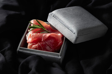 Prosciutto with rosemary in a gray gift box.