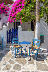 Traditional alley with whitewashed houses,an exterior of a greek tavern  and a  bougainvillea in Prodromos Paros island
