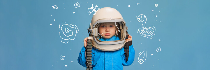 Creative design with drawn elements. Portrait of little boy, child in costume of astronaut over blue background. Feeling sad