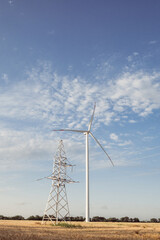 Windmill produces energy for transmission line. Power transmission line tower functions and...