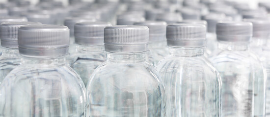 A large number of plastic bottled water products in a drinking water plant that are arranged in a row waiting to be sold to supermarkets. Beverage and drinking water business.
