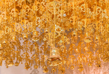 Close up on a hung buddhist gilded baldachin named tengai adorned with multiple golden jingle bell which symbolizes the parasol used formerly in India to protect the Buddha during his prayers. © kuremo