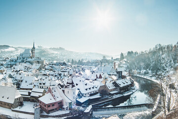 Český Krumlov, UNESCO. Historical town with Castle and Church at sunrise. Beautiful winter morning landscape with an illuminated monument. Snowy cityscape scene from the Cesky Krumlov, Czech Republic