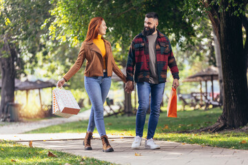 Happy couple with shopping bags in the park
