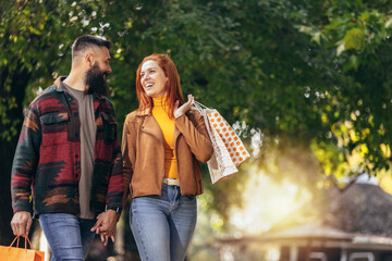 Happy couple with shopping bags in the park