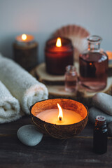 Concept of natural essential organic oils, Bali spa, beauty treatment, relax time. Atmosphere of relaxation, pleasure. Candles, towels, dark wooden background. Alternative oriental medicine
