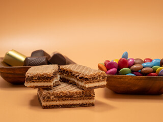 Candies of different varieties on an orange background.