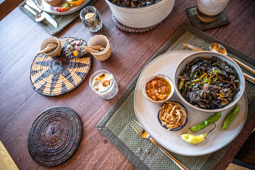 Plates of food on a wooden table in a rustic cabin in the Rocky mountains - family dinner gourmet vegan lifestyle