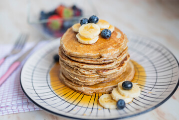 sweet dish Belgian waffles with blueberries and bananas on a blue background