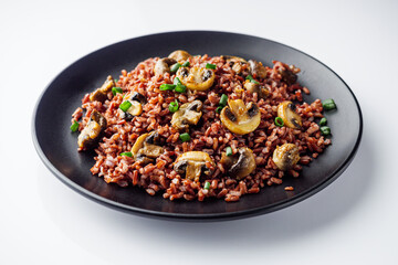delicious red rice with mushrooms on a white background