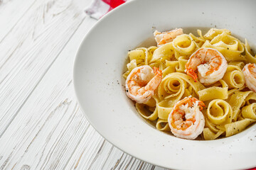 delicious shrimp fettuccine alfredo pasta on a white rustic background