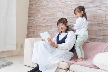 子供を抱きながらタブレットを操作する女性