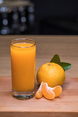 Freshly squeezed tangerine juice on a wooden plate