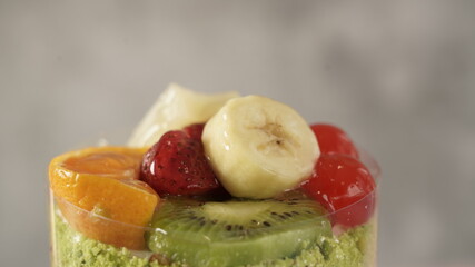 fruit cake with banana, orange, cherry, kiwi and blackberry on it