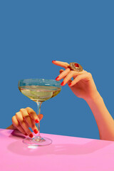 Female hands holding glass with champagne over blue pink background. Festive celebration. Food pop art - obrazy, fototapety, plakaty