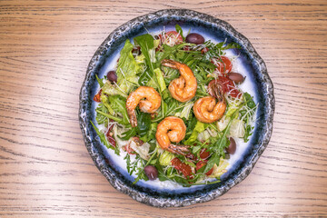 Restaurant dish salad with shrimp and olives