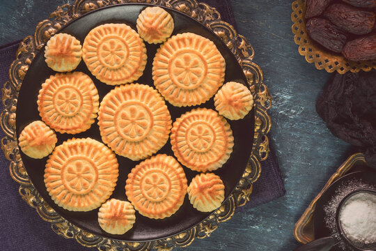 Arabic Cuisine; Middle Eastern traditional dates cookies "Maamoul" or "Mamool". It's a filled butter cookies made with semolina flour and filled with dates or nuts. Top view with close up.