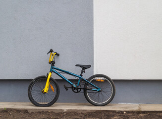 two color kid bicycle at wall.