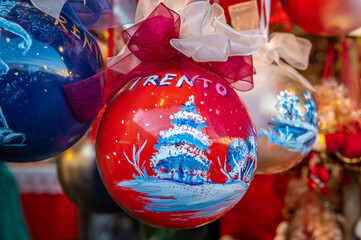 Christmas decorations at the traditional Christmas - Christmas market souvenir, markets of Trento city - northern Italy. Selective focus with shallow depth of field