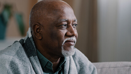 Unhealthy mature elderly grandpa looking away in window pensive sick African American man suffering...