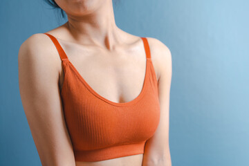 Close up pretty asian model with orange bra nice body isolated on background.