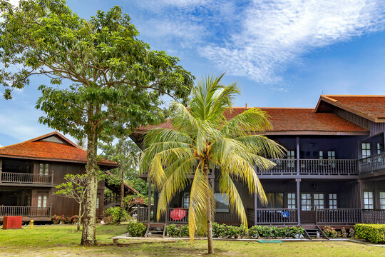 Malaysia, Langkawi, November, 2022: Wooden bungalow among a beautiful garden with tall palm trees on the territory of Pelangi Beach Resort Spa hotel, Langkawi