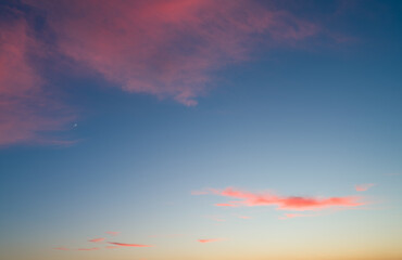 Red clouds and new moon in blue sky